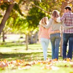 Rear View Of Family Walking Through Autumn Woodland