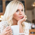 Young woman drinking cup of coffee in restaurant